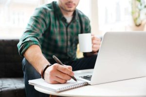 Mann mit Laptop am Sofa